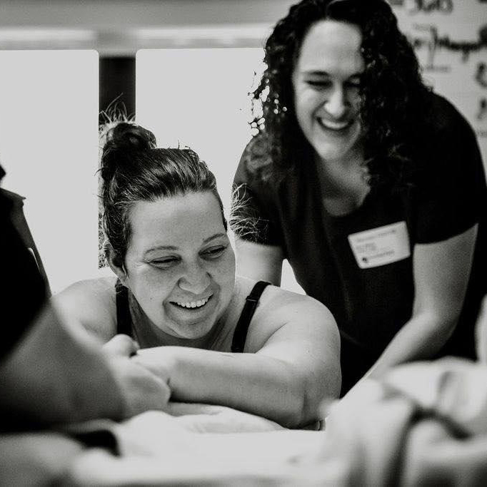 Grayscale photo of a birth doula supporting a mother in labor